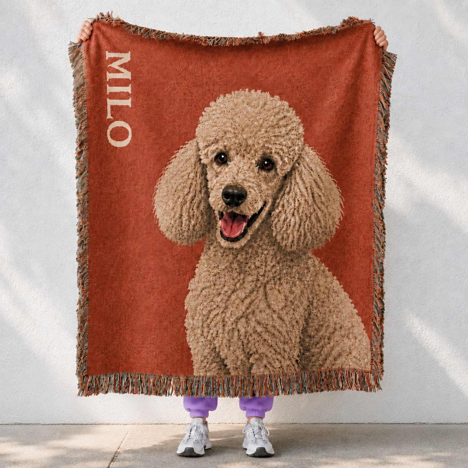Personalized pet woven Blanket with a poodle design and 'Milo' text held by a person , cinnamon color 